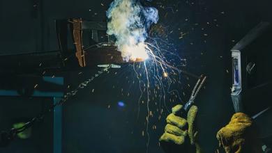 stock-photo-manufacture-worker-welding-metal-sparks-factory